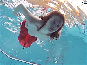 red dressed teen swimming with her eyes opened