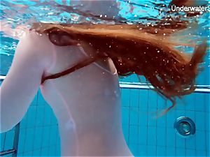 sandy-haired Simonna showcasing her figure underwater
